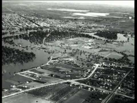 Aerial view of 1956 Murray River flood, has the town at the top with trees and rivers, at the bottom is a fields and towns, houses and roads.