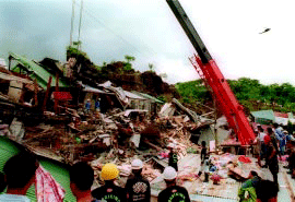 Effects of 1999 Cherry Hill Subdivision landslide with damaged houses and people helping in search and rescue operations.