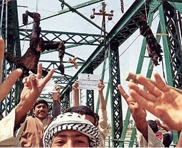 Jubilant Iraqis posing with the charred corpses