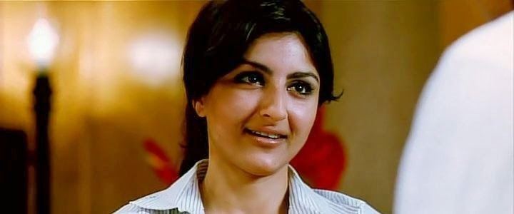 Soha Ali Khan as Pooja smiling, with black hair and wearing a striped polo shirt in a movie scene from 99, a 2009 Indian Hindi-language crime-comedy film.