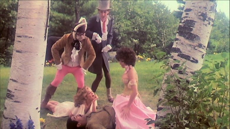 Bree Anthony sitting on the top of the man while Kristine De Bell, Larry Gelman, and Alan Novak looking at them in a scene from the 1976  film, Alice in Wonderland