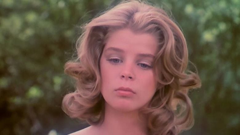 Kristine De Bell with a blonde curly hair in a scene from the 1976 American musical fantasy adult film, Alice in Wonderland