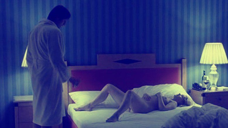 Naked Petra Morzé lying on the bed while Andreas Patton looking at her in a movie scene from Antares (2004 film)