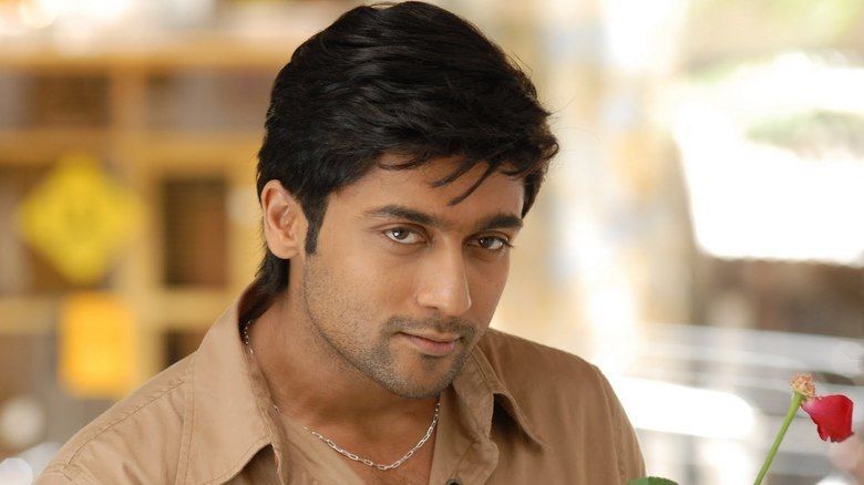 Suriya as Devaraj Velusamy wearing a brown polo shirt.