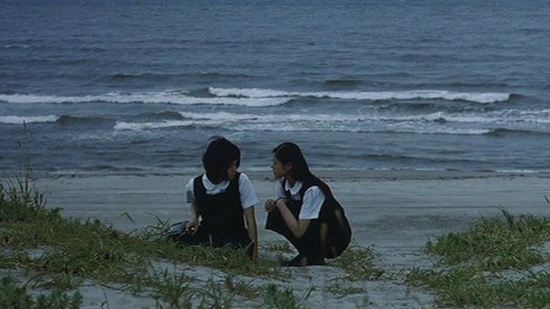 Mikako Ichikawa	as Kayako Kirishima and Manami Konishi as Masami Endo talking with each other on a beach and wearing their school uniforms in a scene from Blue, a 2002 Japanese romantic drama.