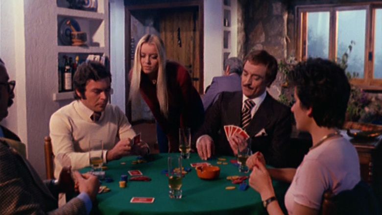 Gloria Guida as Daniela watching four men playing cards and drinking in a scene from Blue Jeans,1975.