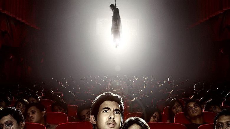 Chantavit Dhanasevi looking scared while sitting in a movie theater in amidst of dead bodies and another dead body hanging above