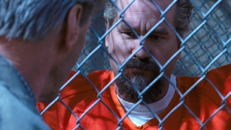 Val Kilmer as John Smith talking to someone and wearing an orange prison outfit in a scene from the movie Felon, 2008.