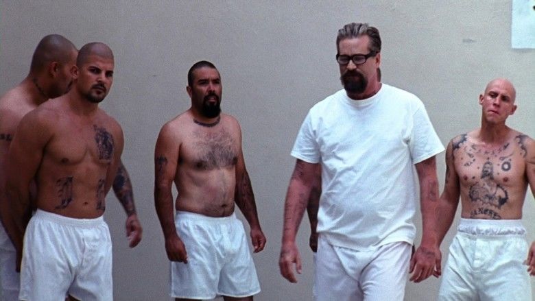 Val Kilmer as John Smith with other prison inmates and wearing a white shirt in a scene from the movie Felon, 2008.