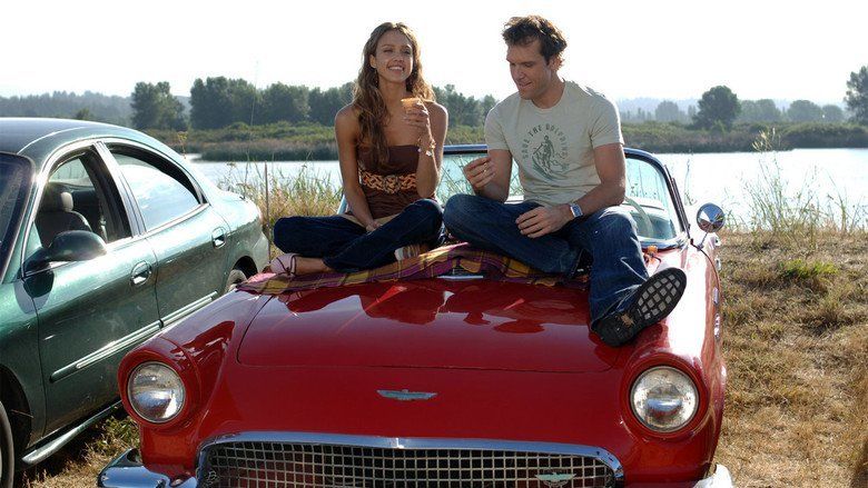 Jessica Alba and Dane Cook are smiling while sitting on the car hood in a scene from the 2007 American comedy film, Good Luck Chuck