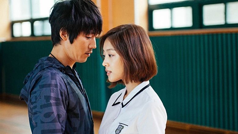 Jang Hyuk is looking at Jo Bo-ah while he is wearing a blue jacket and Jo Bo-ah is wearing a white polo shirt in a scene from the 2014 film, Innocent Thing