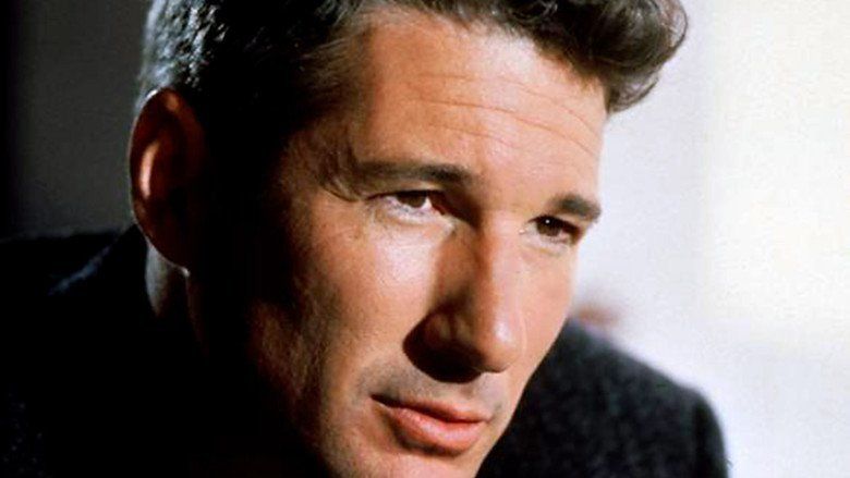 Richard Gere looking at something with a serious face in a scene from the 1990 American crime thriller film, Internal Affairs while wearing a black shirt