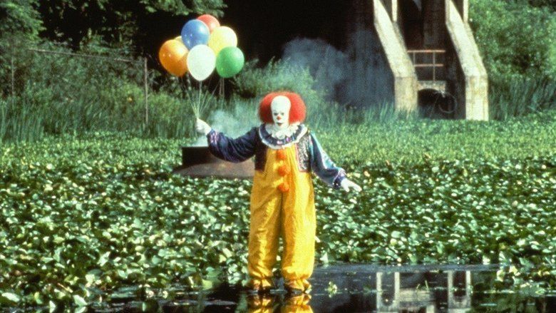 Tim Curry as Pennywise, holding a balloon in a vegetable plantation, a scene from the 1990 psychological horror drama miniseries, It