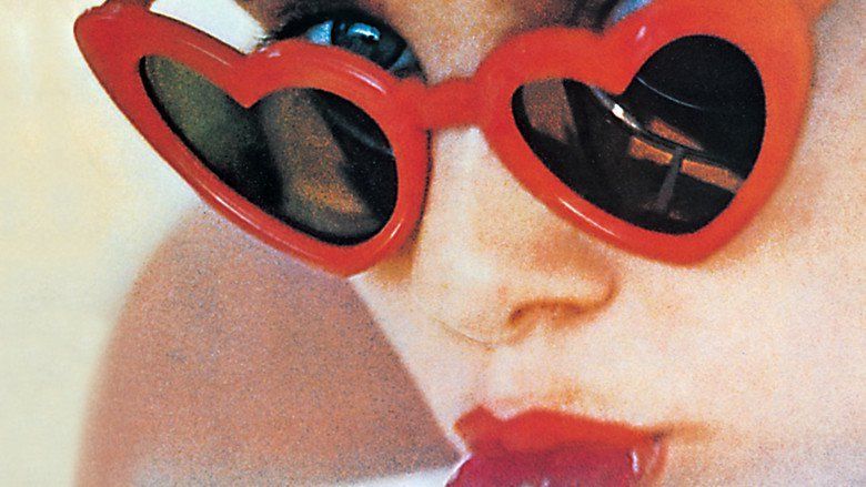 Sue Lyon as Lolita licking a lollipop and wearing heart-shaped sunglasses.