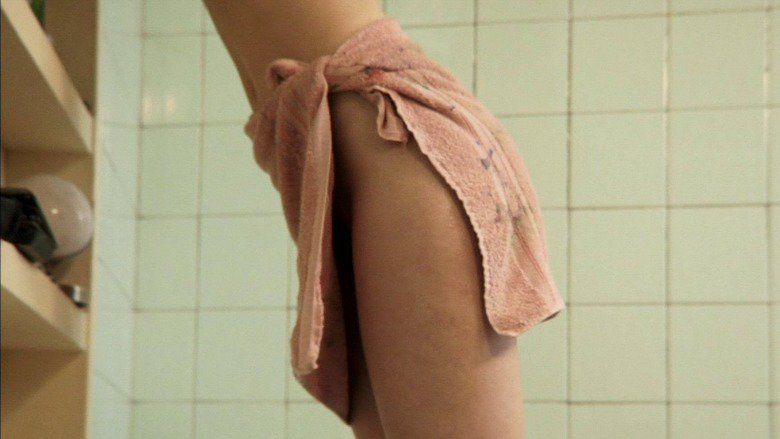 María Valverde wearing a towel wrapped around her waist in a scene from the 2011 Spanish drama film, Madrid, 1987