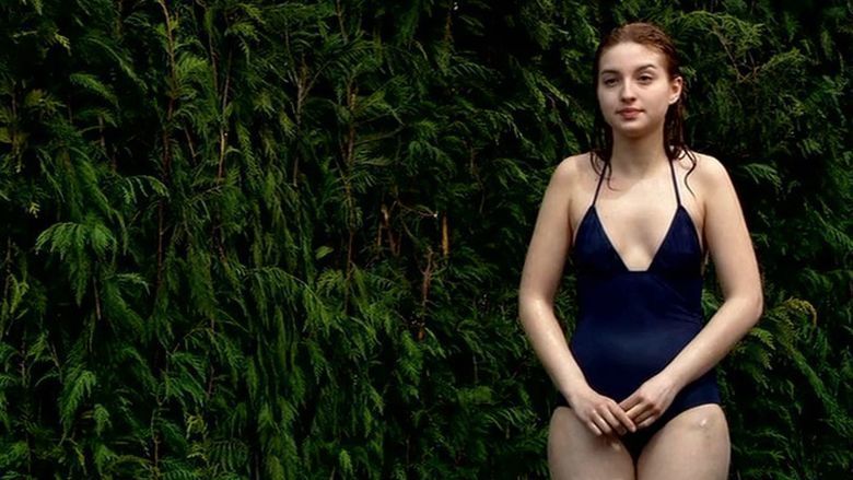 María Valverde with a wet look while wearing a blue one-piece swimsuit in a scene from the 2005 erotic drama film, Melissa P.