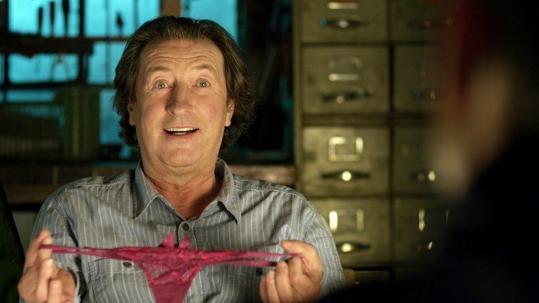 Bolek Polivka smiling while holding a woman's pink underwear in a scene from the 2011 Sexy Comedy Film "Men in Hope"