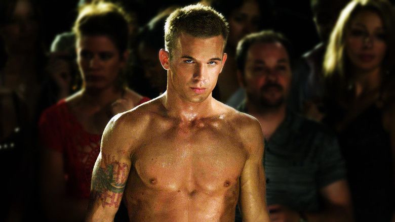 Cam Gigandet with a furious look at a crowd in the background in a scene of the 2008 American martial arts film “Never Back Down”. Cam has black hair with a tattoo on his left arm and is topless with abs showing
