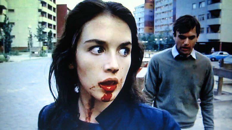 Isabelle Adjani with blood on her mouth while Sam Neill at her back wearing a gray sweatshirt in a scene from the 1981 film, Possession