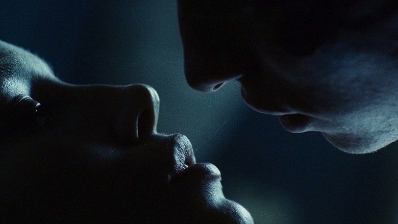 Jessica Biel and Eddie Redmayne looking closely at each other in a dark place in a scene from the 2008 drama film, Powder Blue