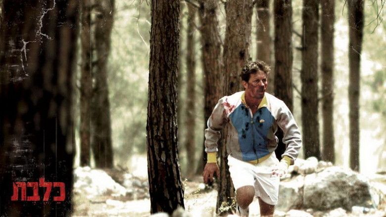 Ofer Shechter running in the forest with blood on his face while wearing a white and blue jacket in a scene from the 2010 Israeli film, Rabies