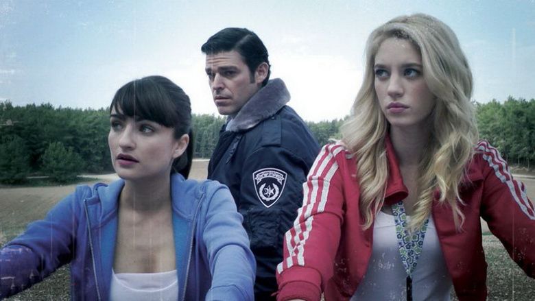 Ania Bukstein, Yael Grobglas, and the man at the back are looking afar while they are wearing jackets in a scene from the 2010 Israeli film, Rabies