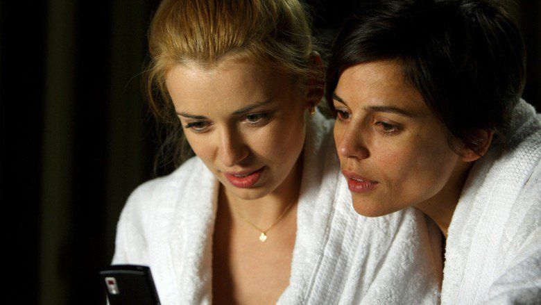 Elena Anaya as Alba and Natasha Yarovenko as Natasha looking at a phone and wearing white robes in a scene from Room in Rome, 2010.