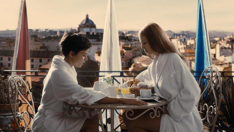 Elena Anaya as Alba and Natasha Yarovenko as Natasha looking eating breakfast and wearing white robes in a scene from Room in Rome, 2010.