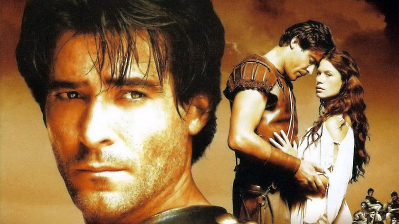 On the left, Goran Visnjic with a serious face, with a thin beard and mustache, and wearing armor. On the right, Goran Visnjic and Rhona Mitra with serious faces and holding each other in a movie scene from Spartacus, 2004 North American miniseries.