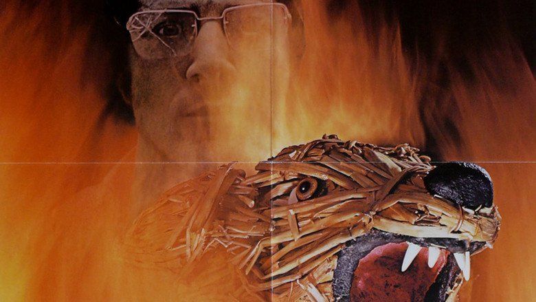 Movie poster of Straw Dogs, a 1971 psychological thriller film featuring Dustin Hoffman with a serious face and wearing broken eyeglasses with a figure of a dog made out of straw.
