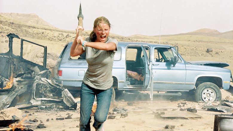 Emilie de Ravin running while holding an ax in a movie scene from the 2006 film The Hills Have Eyes