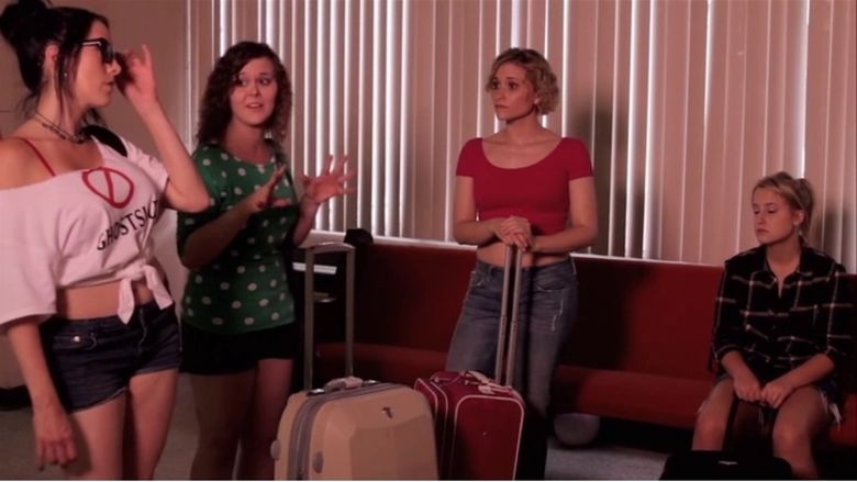 Scene from the movie "The Hospital" featuring four girls talking with each other and carrying their luggage.