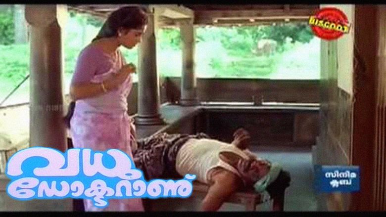 Jayaram as Sidharthan lying on a chair and wearing a white sleeveless shirt while Nadia Moidu as Ammukutty looking at him, with long hair, and wearing a purple Indian traditional dress in a movie scene from Vadhu Doctoranu (1994 film).