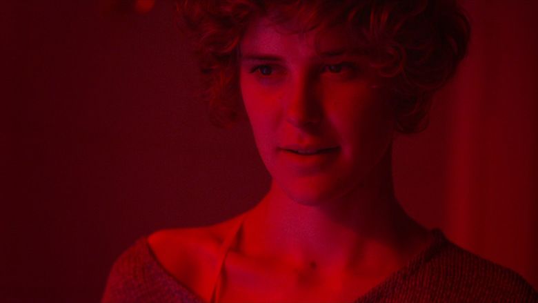 Carla Juri with a tight-lipped smile while wearing a blouse in a scene from the 2013 German drama film, Wetlands
