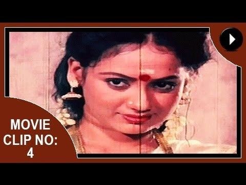 Movie clip no. 1 of Aadhi Thaalam, a 1990 Indian Malayalam film starring Jayarekha with a fierce look, wearing earrings, necklace, and white top.