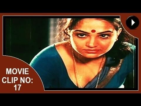Movie clip no. 17 of Aadhi Thaalam, a 1990 Indian Malayalam film starring Jayarekha with a serious face, curly hair, wearing a necklace, and a blue-green Indian dress.
