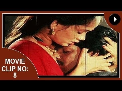 Movie clip no. 8 of Aadhi Thaalam, a 1990 Indian Malayalam film starring Jayarekha with closed eyes while hugging a man, wearing earrings, a necklace, and a red Indian dress.