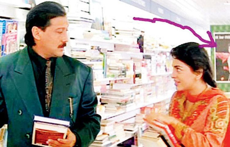 Juhi Chawla and Jackie Shroff holding a book in a movie scene from the 1993 romantic drama film Aaina