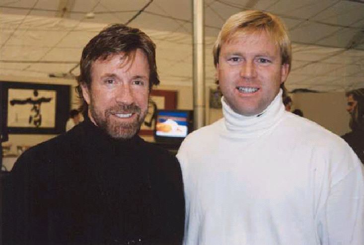 Chuck Norris smiling and wearing black sleeves with his younger brother Aaron Norris in white sleeves
