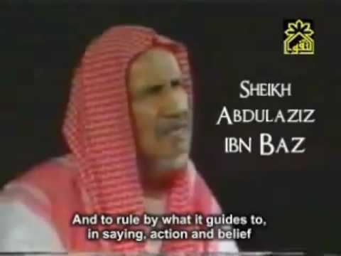 Abd al-Aziz ibn Baz giving a speech and wearing a  red and white kufiyah.