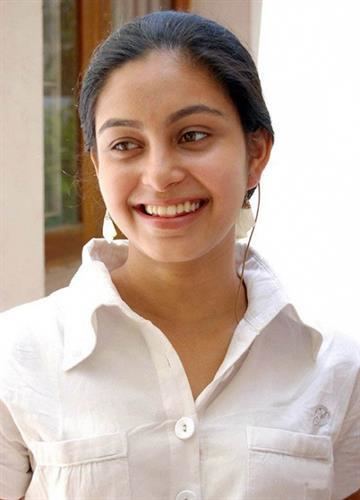 Abhinaya smiles while wearing a white sleeve and earrings