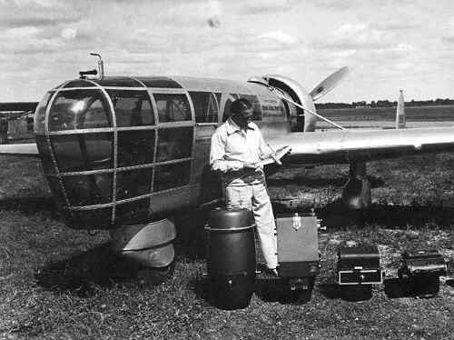 Ted Abrams standing beside his P-1 Explorer and its aerial camera gear. Ted is wearing a long sleeve and pants