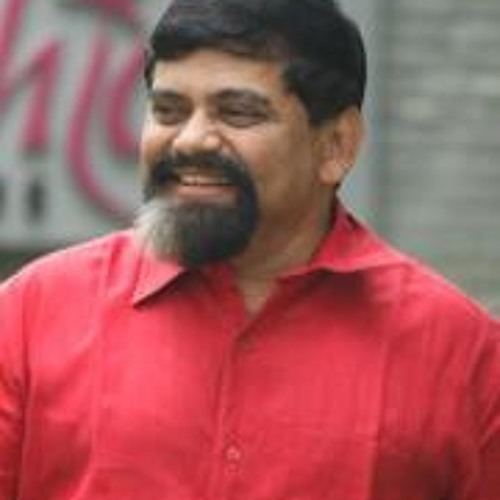 Achyut Godbole wearing red polo while smiling