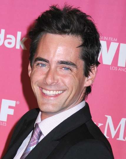 Adam Kaufman showing a wide smile and wearing a white-striped sleeve and black suit during the 2009 Women in Film Crystal and Lucy Awards