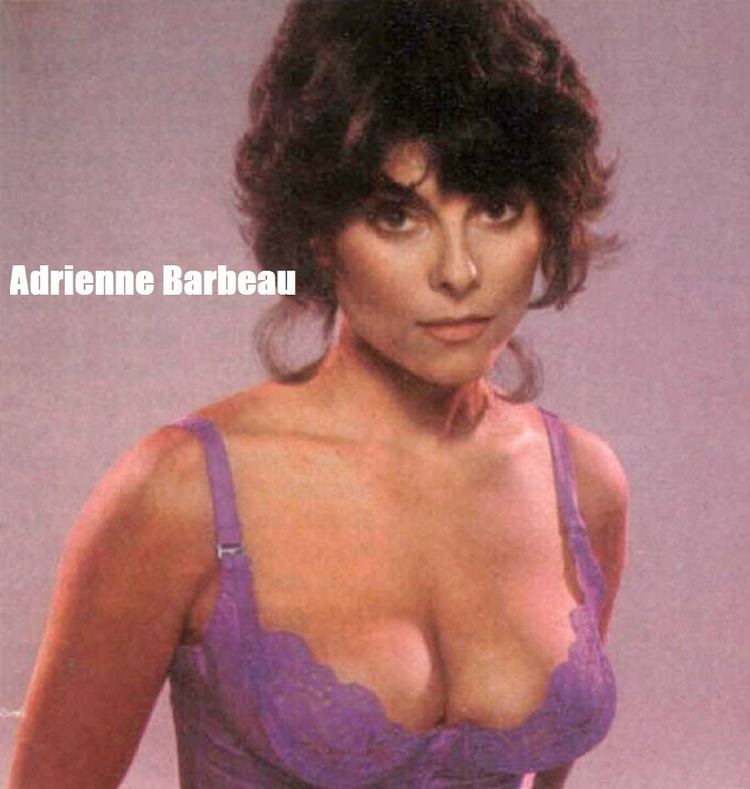 Adrienne Barbeau with a serious face, with messy-look hair, and wearing purple lingerie.