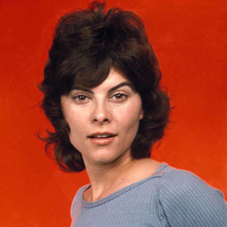 Adrienne Barbeau smiling, with short hair, and wearing a gray shirt.