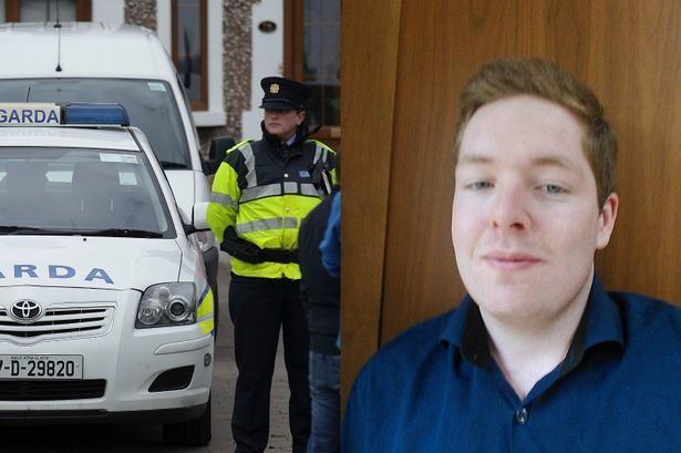 On the left is Garda police officer and on the right is Fearghal O Snodaigh wearing blue long sleeves