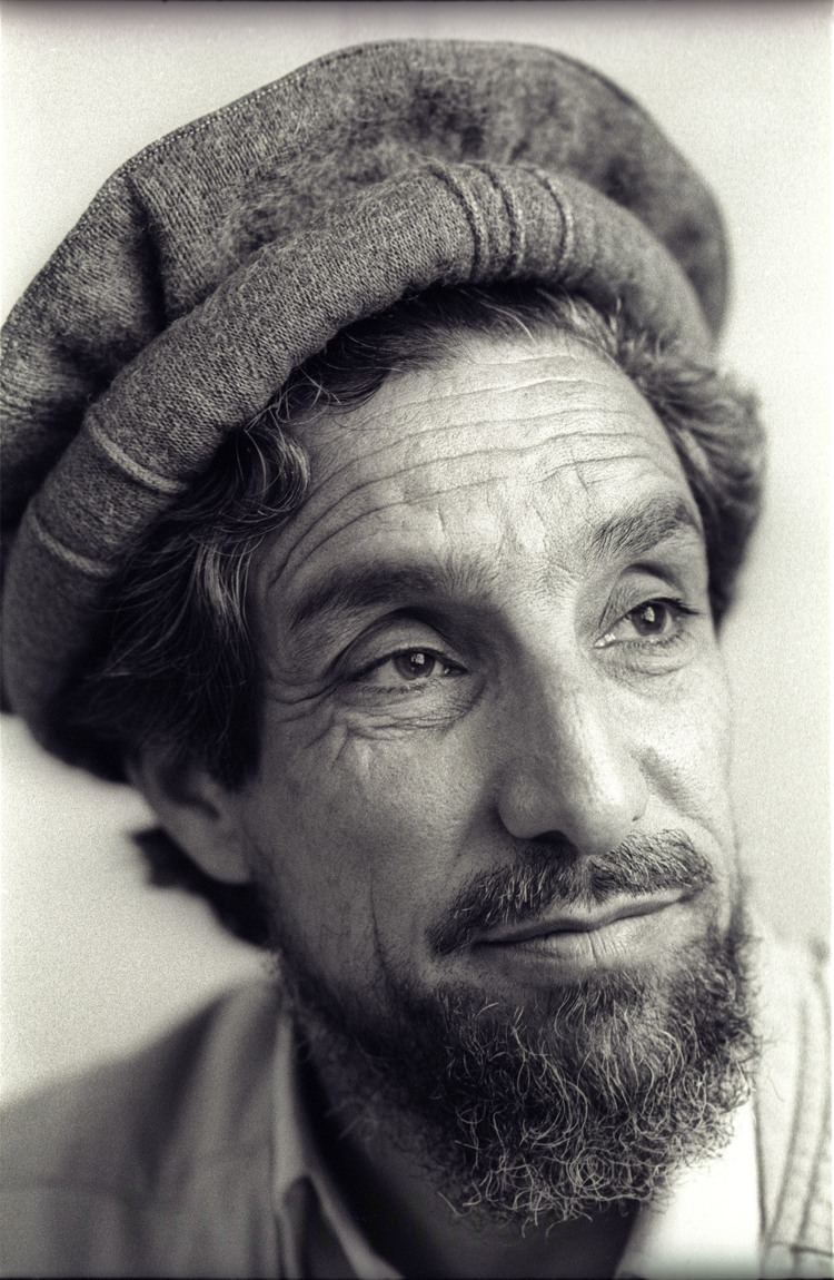 Ahmad Shah Massoud looking at something and wearing a brown desert hat and with thicker facial hair.