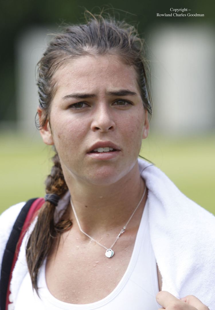 Ajla Tomljanovic with braided hair and wearing a white top and necklace