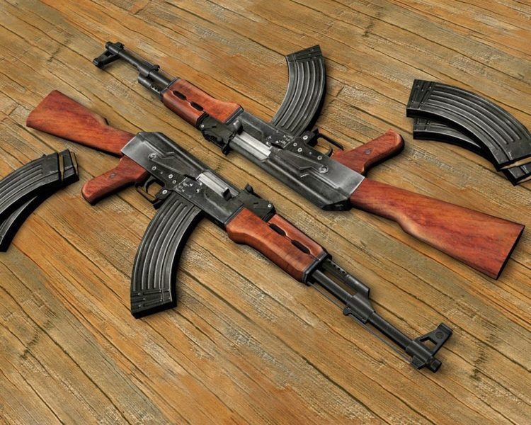 Two AK 47 and 4 magazines on a wooden floor